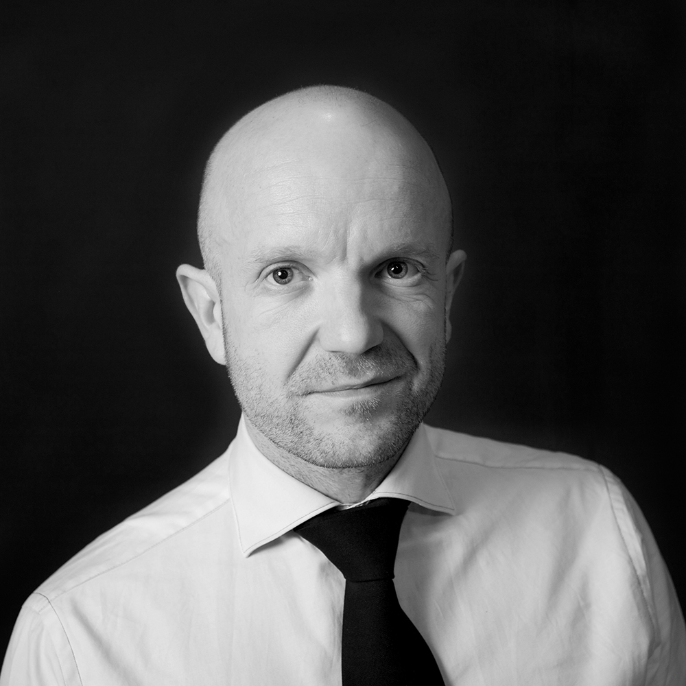 Bison Managing Director Mark Bidwell In Black And White Wearing A Suit